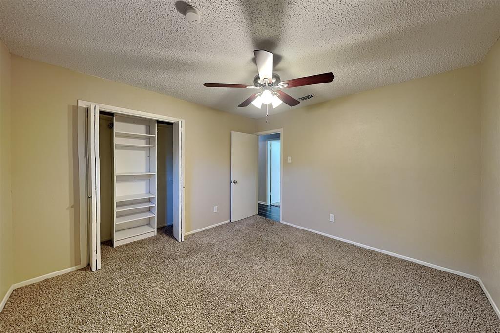 433 Arwine Drive Hurst, TX 76053 - Photo 14 of 18 an empty room with closet and a ceiling fan