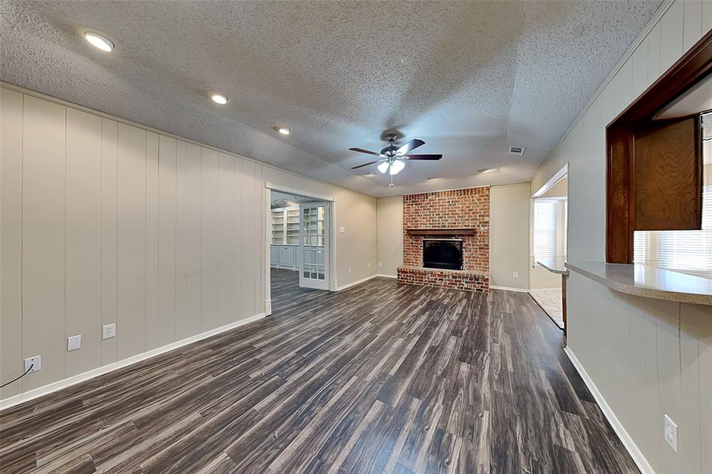 433 Arwine Drive Hurst, TX 76053 - Photo 2 of 18 a view of an empty room with wooden floor fireplace and a window
