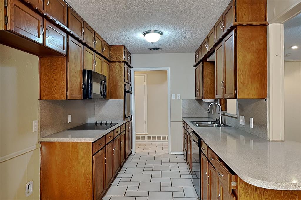 433 Arwine Drive Hurst, TX 76053 - Photo 4 of 18 a kitchen with stainless steel appliances a sink stove and cabinets