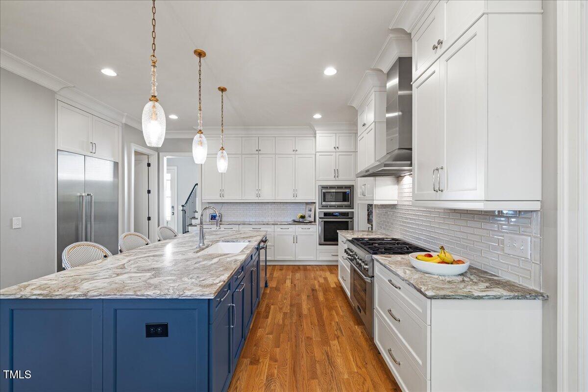 3513 Bellevue Road Raleigh, NC 27609 - Photo 11 of 61 a kitchen with stainless steel appliances granite countertop a sink a stove and a wooden floors