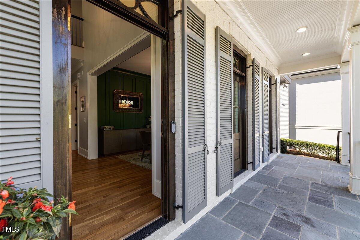 3513 Bellevue Road Raleigh, NC 27609 - Photo 3 of 61 a view of a hallway with wooden floor and a living room filled with furniture