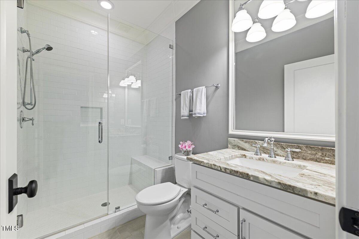 3513 Bellevue Road Raleigh, NC 27609 - Photo 38 of 61 a bathroom with a granite countertop sink mirror toilet and shower