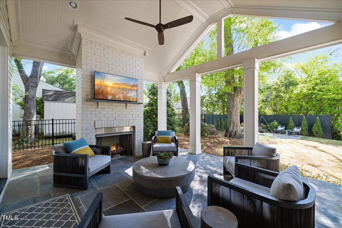 3513 Bellevue Road Raleigh, NC 27609 - Photo 57 of 61 a living room with furniture a fireplace and a floor to ceiling window