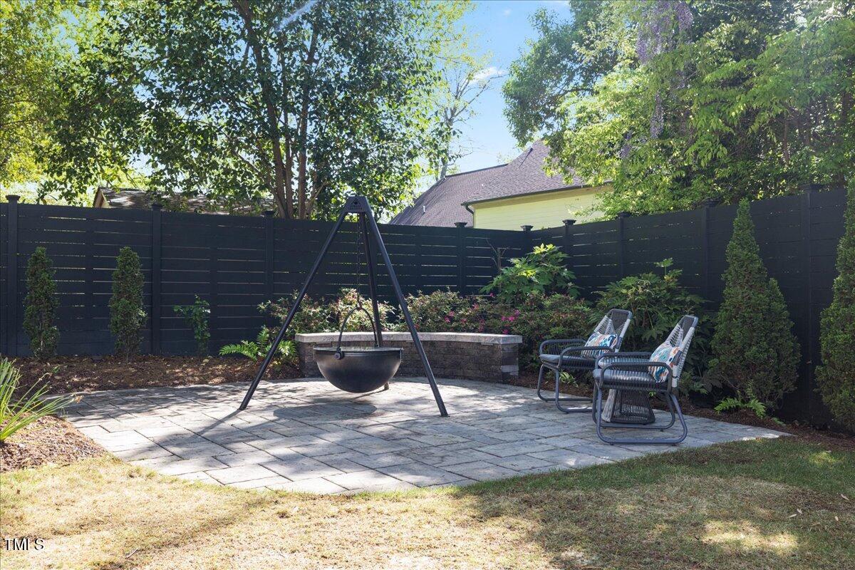 3513 Bellevue Road Raleigh, NC 27609 - Photo 58 of 61 a view of a patio with table and chairs potted plants and a large tree