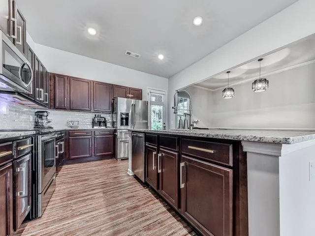 a kitchen with granite countertop stainless steel appliances and wooden cabinets