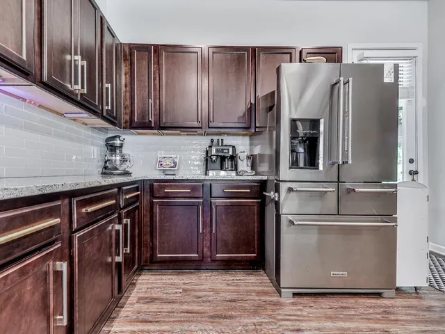a kitchen with stainless steel appliances granite countertop a refrigerator and a sink
