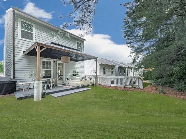 a view of a house with a yard and sitting area