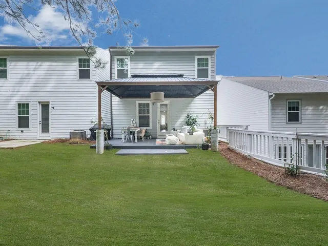 a view of a house with a yard and furniture