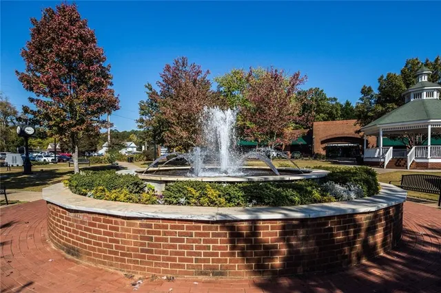 a front view of a house with a yard fountain and a fire pit