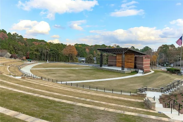 a view of a tennis ground with large trees
