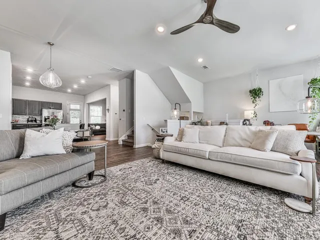 a living room with furniture and kitchen view