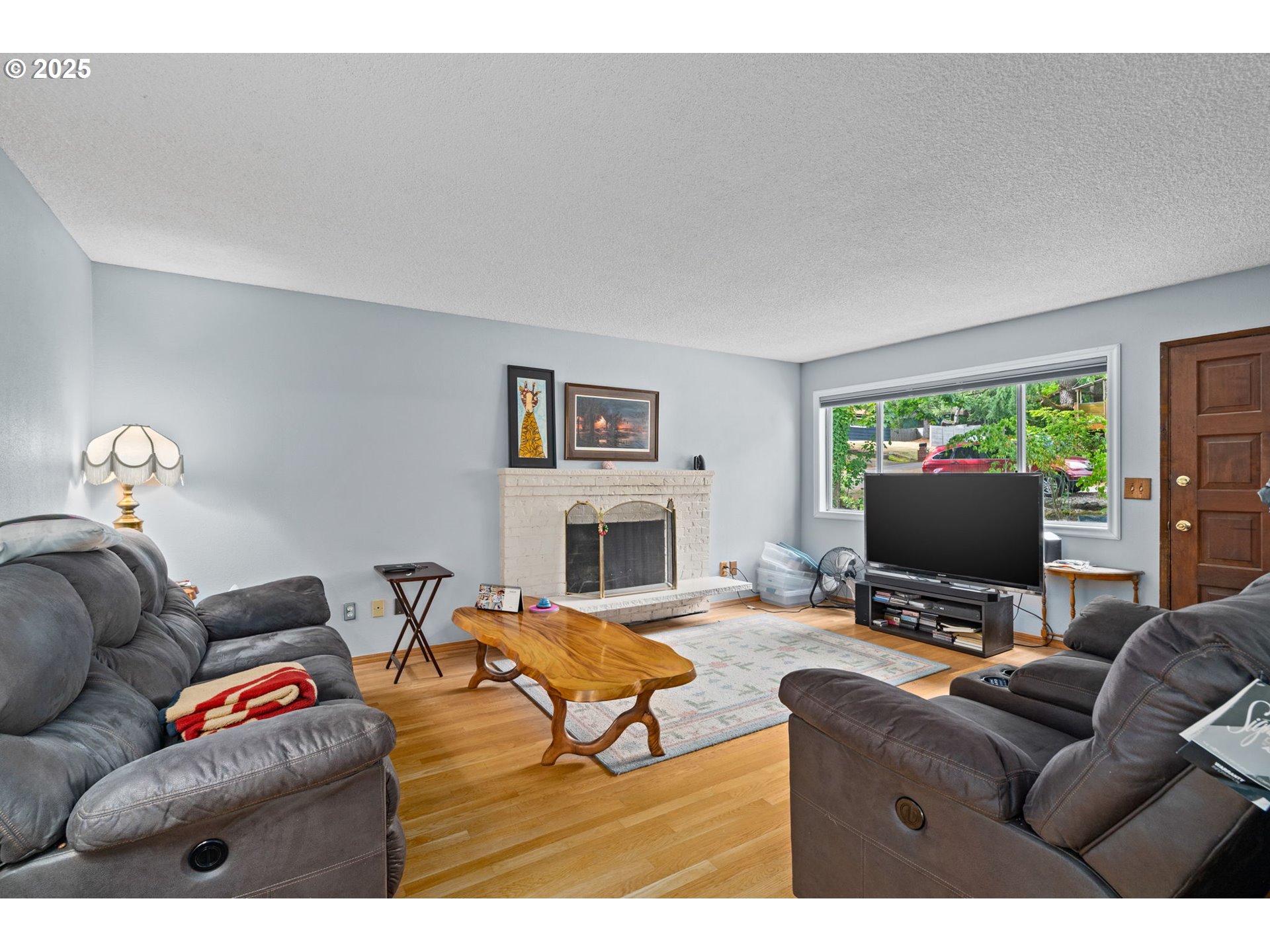 5944 Southwest Wilbard Street Portland, OR 97219 - Photo 3 of 21 a living room with furniture a fireplace and a flat screen tv