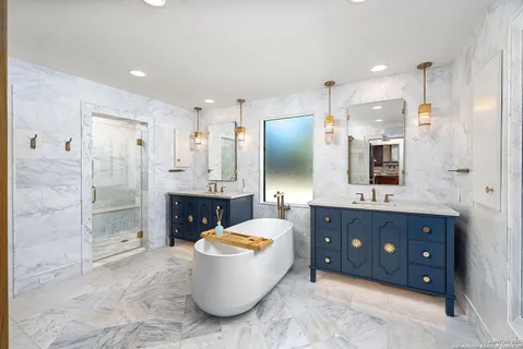 a spacious bathroom with a tub sink shower and mirror