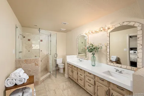 a spacious bathroom with double vanity and a shower