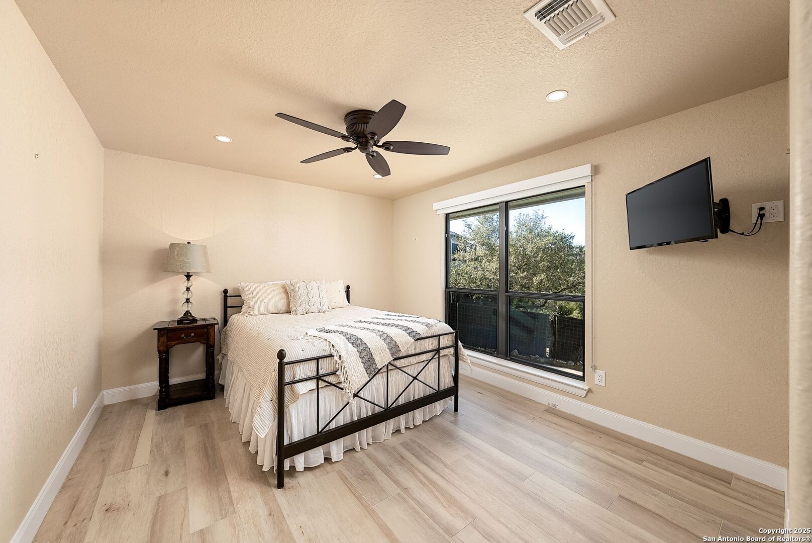 1240 Rip Jay Circle Canyon Lake, TX 78133 - Photo 26 of 52 a bedroom with a large bed and a flat tv screen on dresser