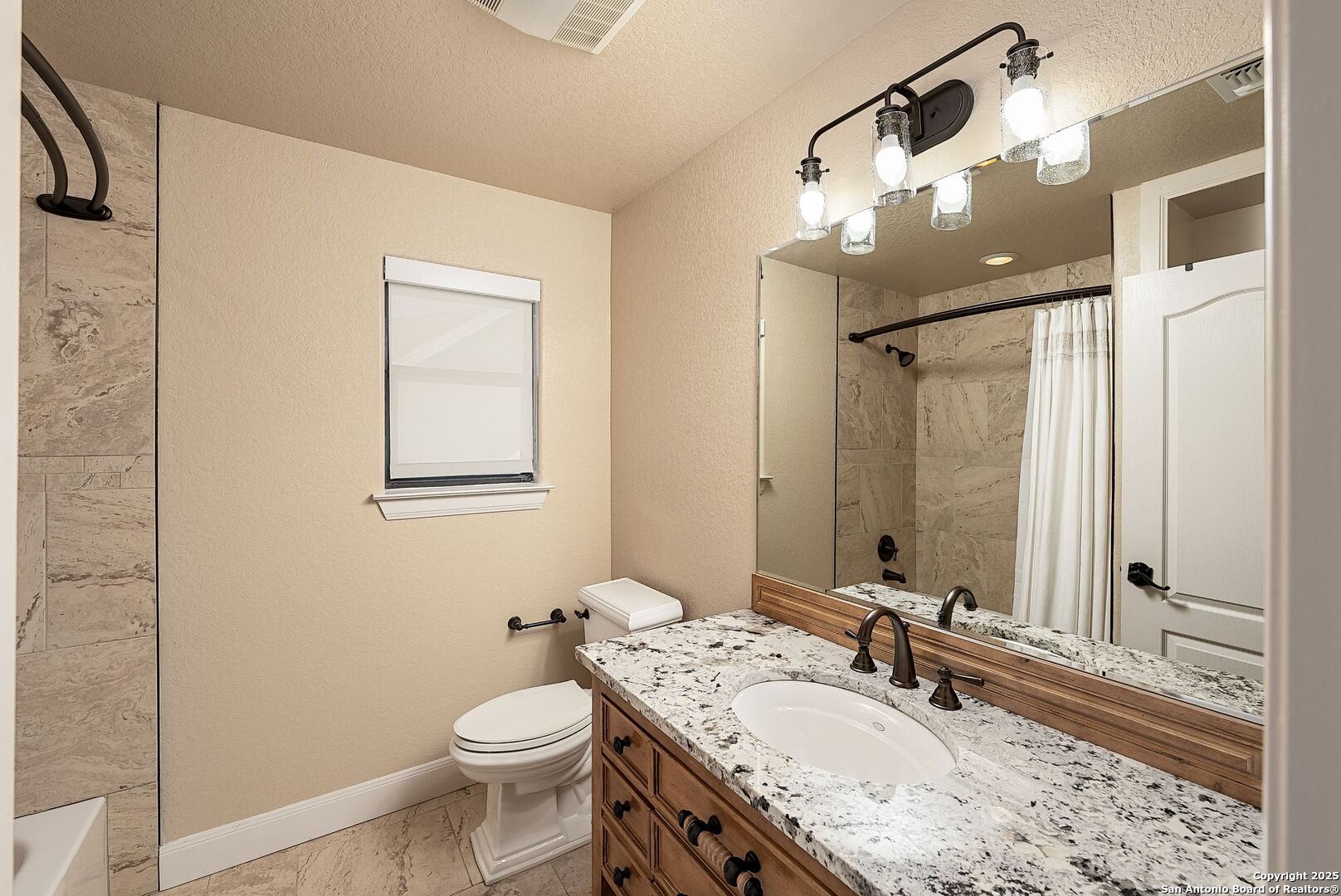 1240 Rip Jay Circle Canyon Lake, TX 78133 - Photo 28 of 52 a bathroom with a granite countertop sink toilet and a mirror