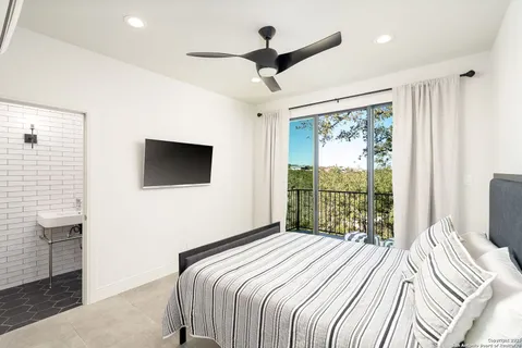 a bedroom with a large bed and a flat tv screen