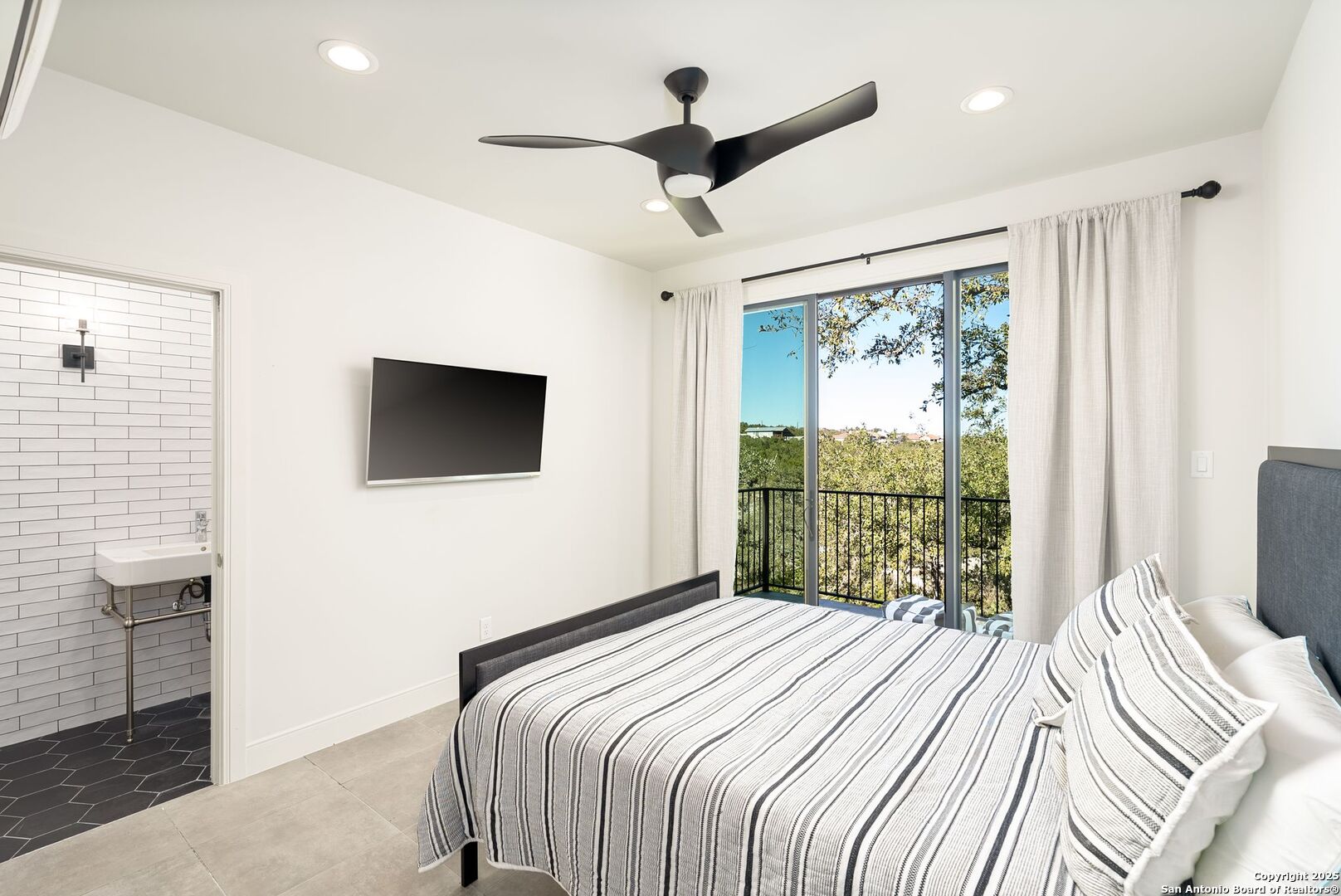 1240 Rip Jay Circle Canyon Lake, TX 78133 - Photo 32 of 52 a bedroom with a large bed and a flat tv screen