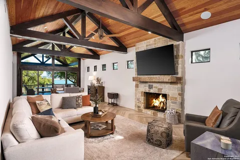 a living room with furniture a fireplace and a flat screen tv