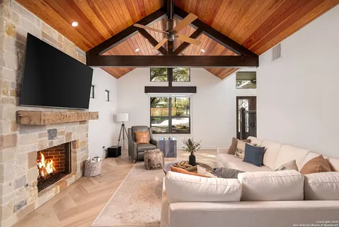 a living room with furniture a fireplace and a flat screen tv
