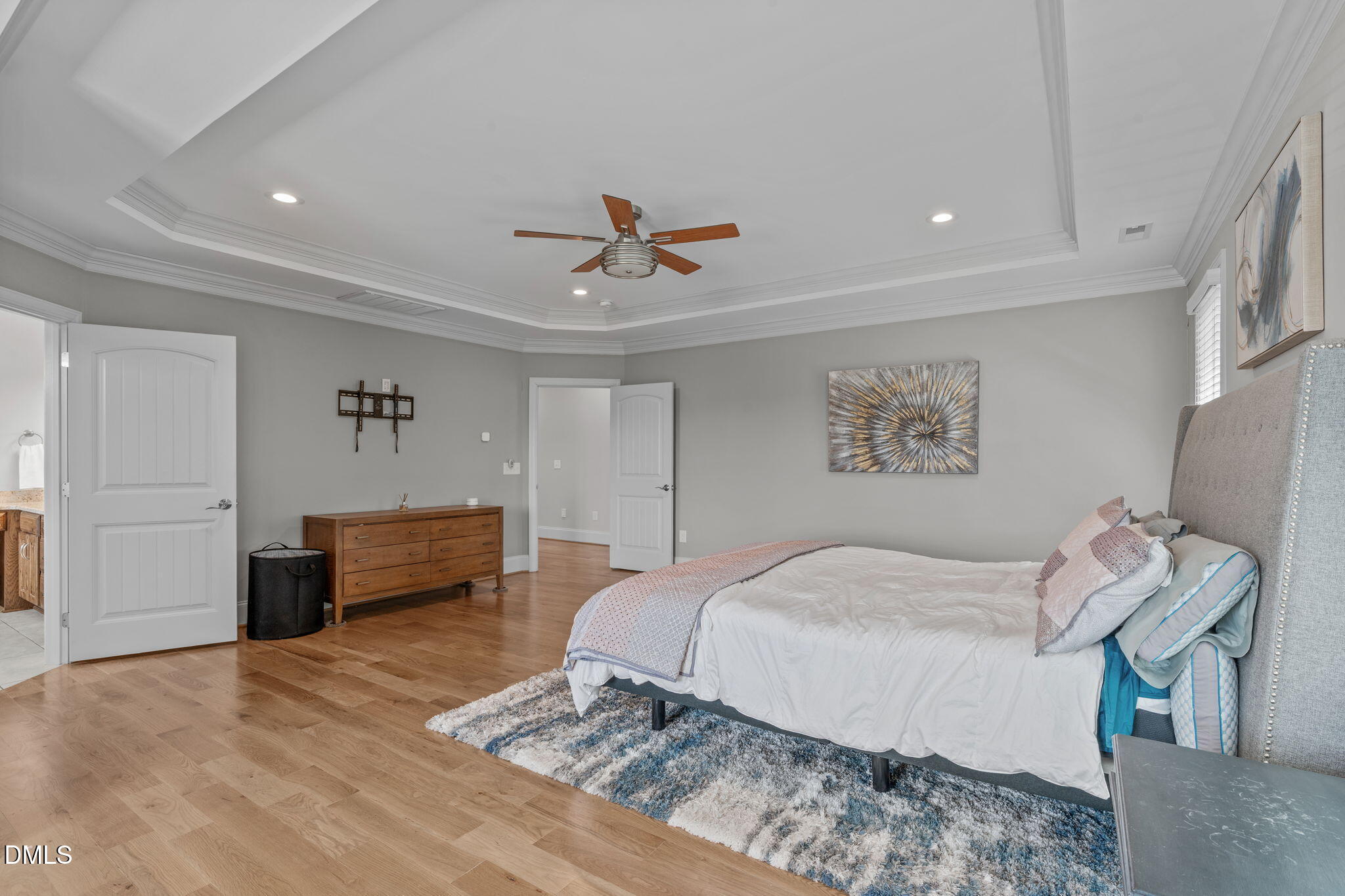 261 Character Drive Rolesville, NC 27571 - Photo 34 of 61 a bedroom with a bed and a chandelier