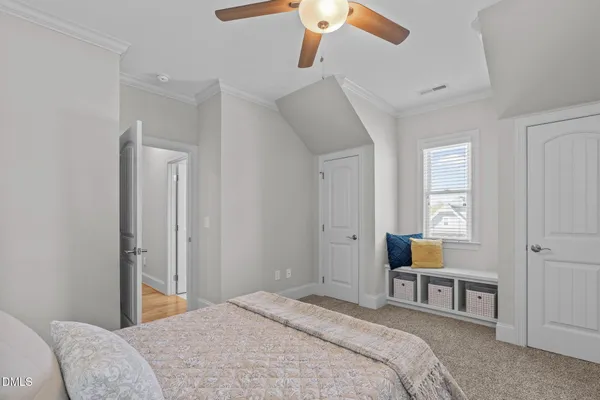 a bedroom with a bed and a flat tv screen on dresser