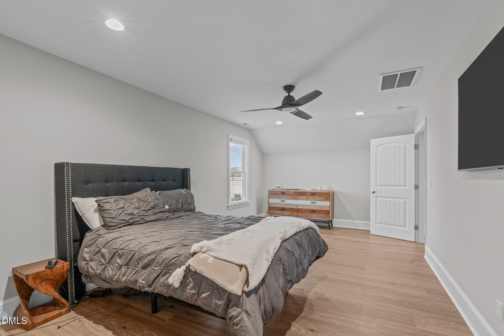 261 Character Drive Rolesville, NC 27571 - Photo 52 of 61 a bedroom with a bed and a flat tv screen on dresser