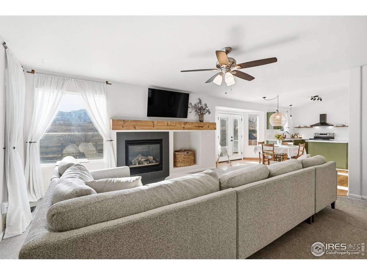1273 Trail Ridge Road Longmont, CO 80504 - Photo 2 of 44 The cozy living room is open to the dining room and kitchen and flows seamlessly out to the large back deck.