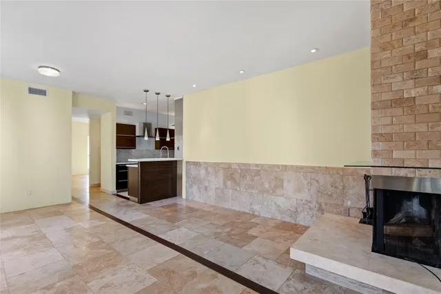 a large kitchen with stainless steel appliances a large counter top and a refrigerator