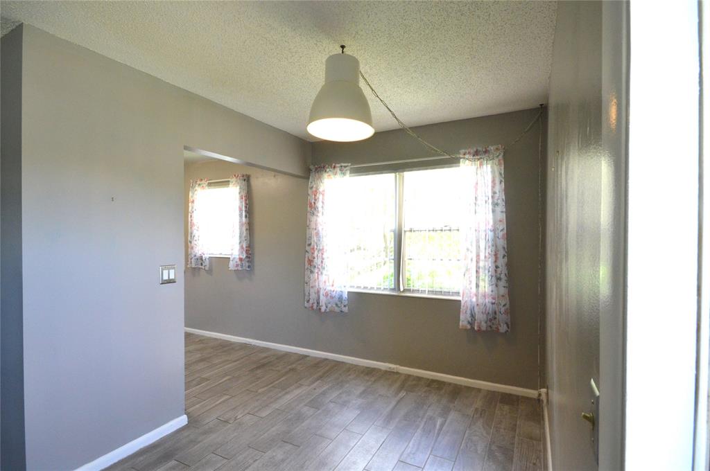 144 Mansfield D, Unit 144 Boca Raton, FL 33434 - Photo 12 of 37 a view of an empty room with wooden floor and a window