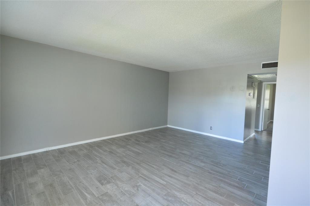 144 Mansfield D, Unit 144 Boca Raton, FL 33434 - Photo 14 of 37 a view of an empty room and wooden floor