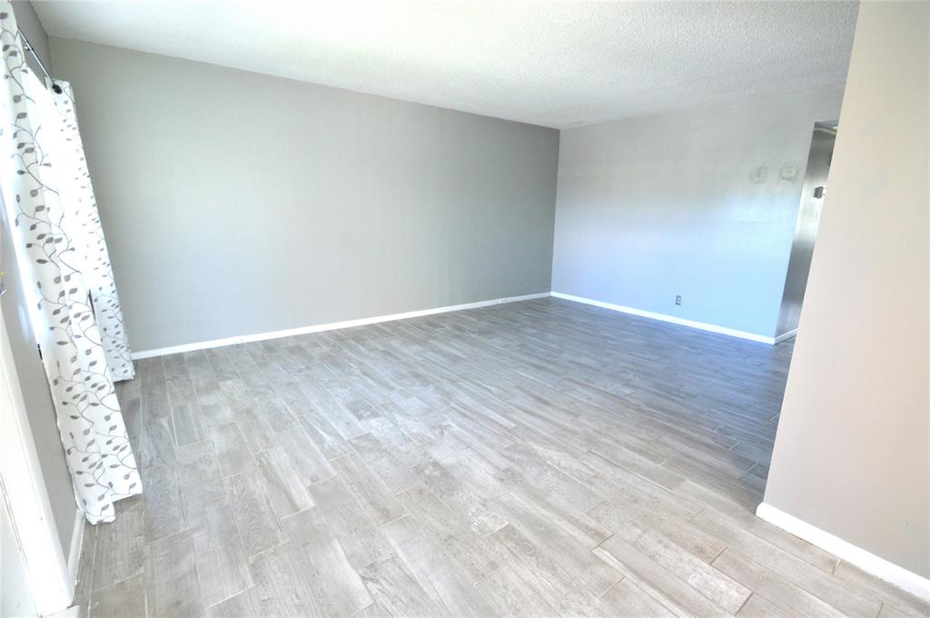 144 Mansfield D, Unit 144 Boca Raton, FL 33434 - Photo 20 of 37 a view of an empty room with wooden floor and a window