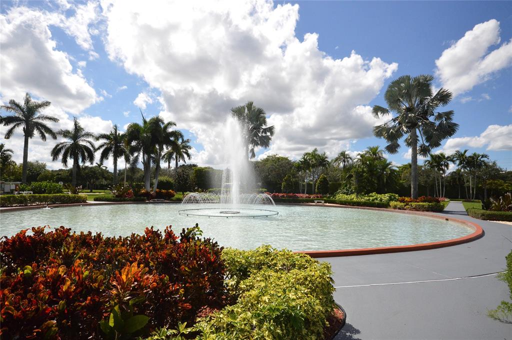 144 Mansfield D, Unit 144 Boca Raton, FL 33434 - Photo 22 of 37 a view of a swimming pool with a patio and a garden
