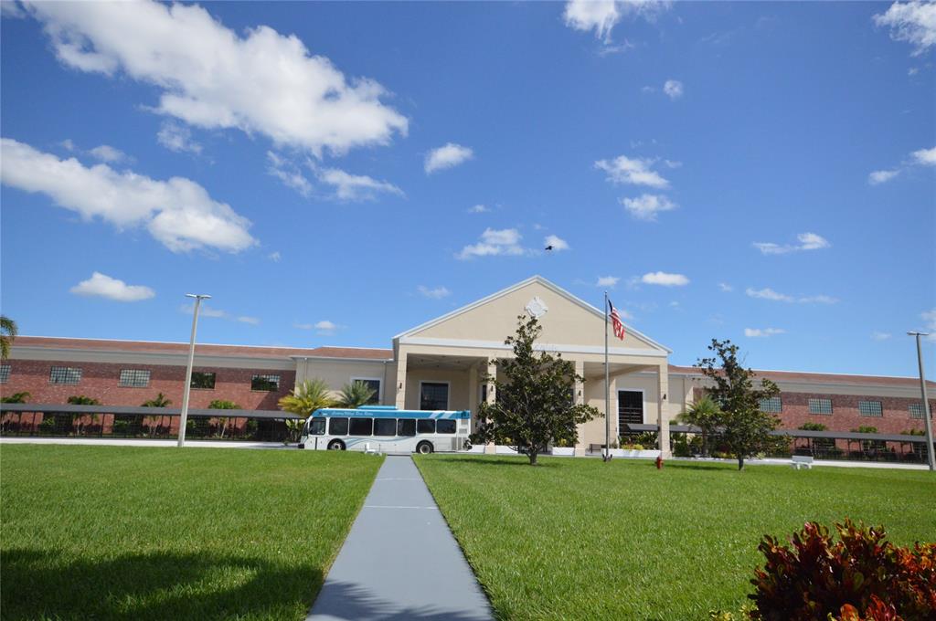 144 Mansfield D, Unit 144 Boca Raton, FL 33434 - Photo 23 of 37 a front view of a house with a yard table and chairs