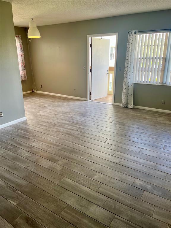 144 Mansfield D, Unit 144 Boca Raton, FL 33434 - Photo 30 of 37 an empty room with wooden floor and windows