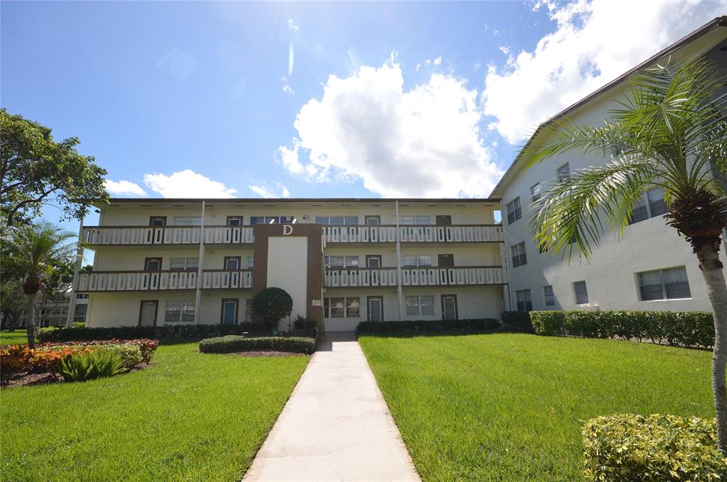 144 Mansfield D, Unit 144 Boca Raton, FL 33434 - Photo 4 of 37 a front view of a house with a garden and yard