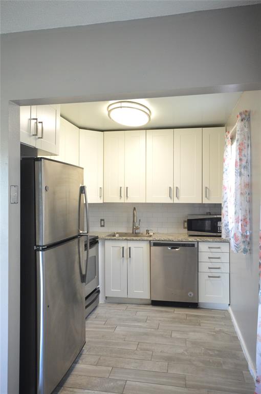 144 Mansfield D, Unit 144 Boca Raton, FL 33434 - Photo 7 of 37 a kitchen with stainless steel appliances a refrigerator sink and cabinets