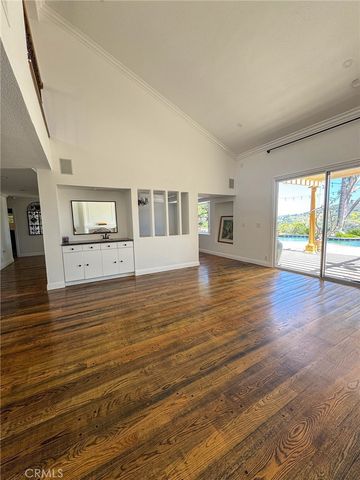 a view of empty room with wooden floor and fireplace