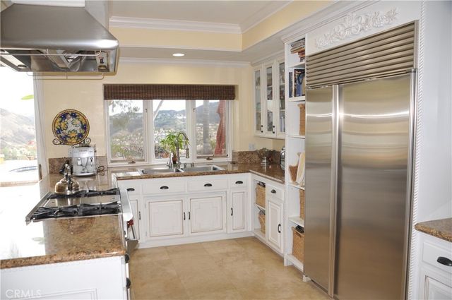 a kitchen with stainless steel appliances granite countertop a refrigerator and a stove