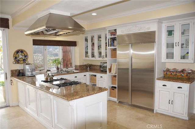 a kitchen with stainless steel appliances granite countertop a sink a stove and a refrigerator