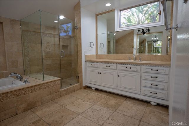 a spacious bathroom with a granite countertop sink mirror and bathtub