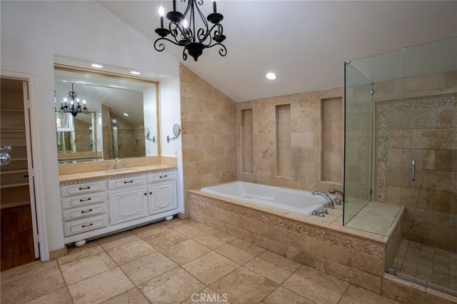 a bathroom with a double vanity sink mirror and bathtub