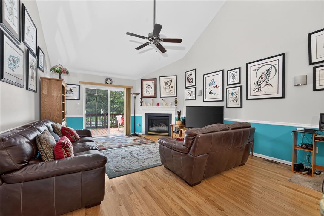 198 Park Ridge Drive Easton, PA 18040 - Photo 8 of 28 Warm hardwood floors and soaring vaulted ceilings create an inviting atmosphere, with a cozy fireplace grounding the spacious living area.