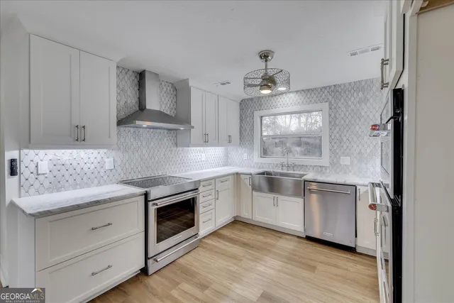 a kitchen with white cabinets stainless steel appliances and sink