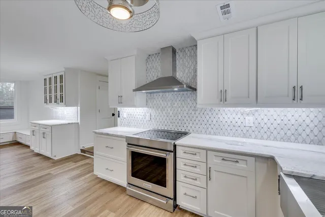 a kitchen with cabinets appliances and a wooden floor