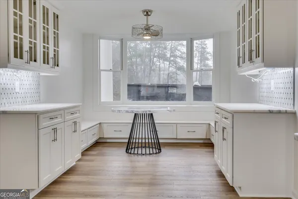 a kitchen with white cabinets and window
