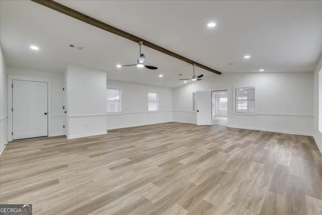 a view of empty room with wooden floor