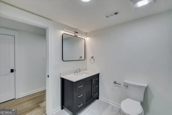 a bathroom with a toilet sink and mirror