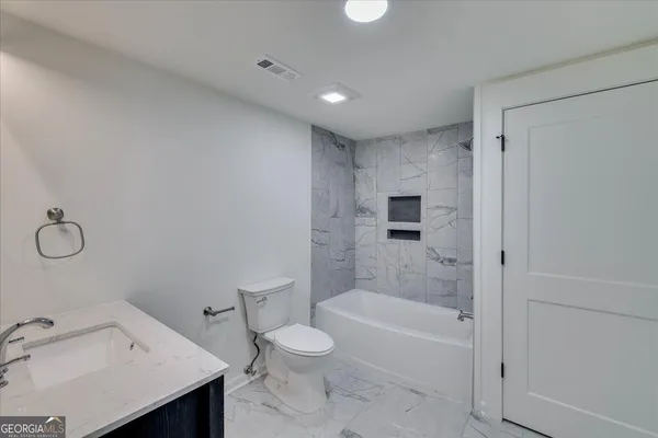 a bathroom with a bathtub toilet and sink