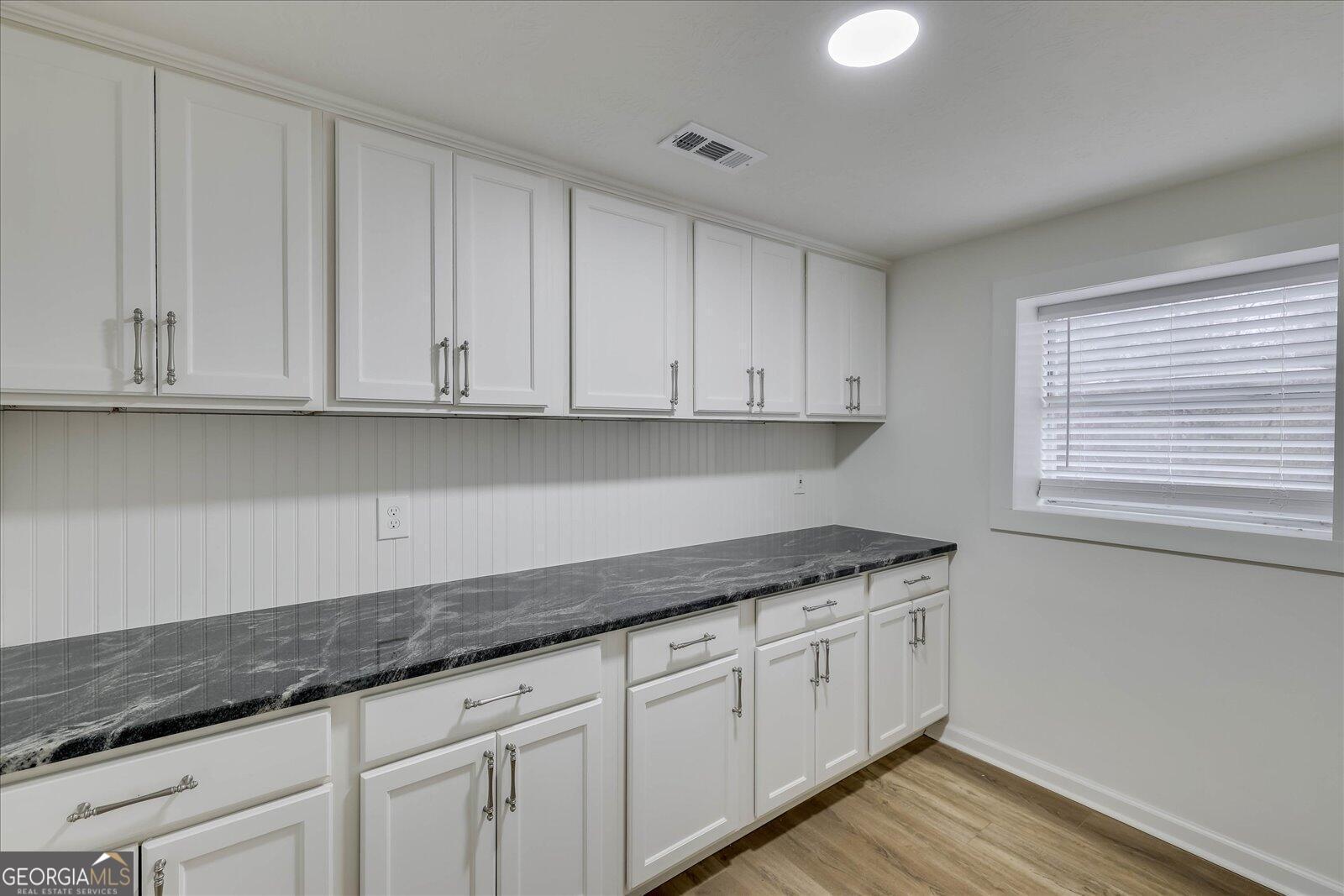 4756 Mike Padgett Highway Augusta, GA 30906 - Photo 20 of 28 a kitchen with granite countertop white cabinets and a hard wood floor
